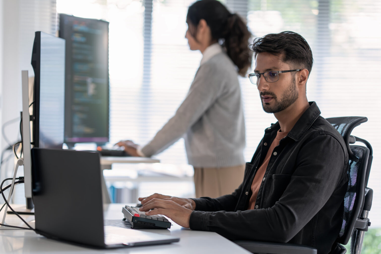Cybersecurity operations analyst reviewing security activity at a workstation